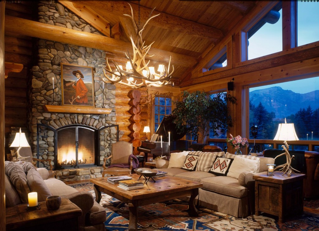 Cozy seating area around a river rock fireplace in a beautiful log home with mountain views.